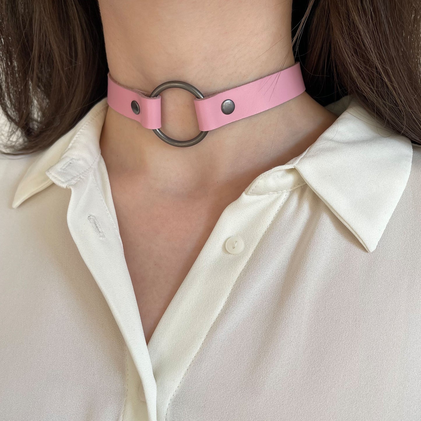 Pink leather choker with black ring – angled view on neck with white shirt