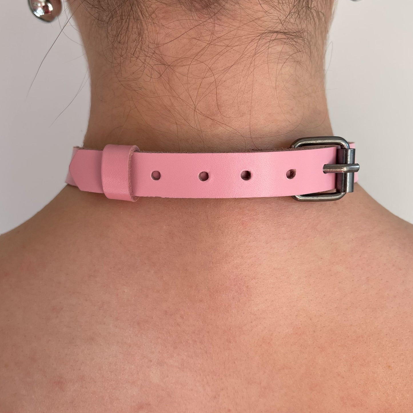 Back view of pink leather choker with black buckle and adjustment holes