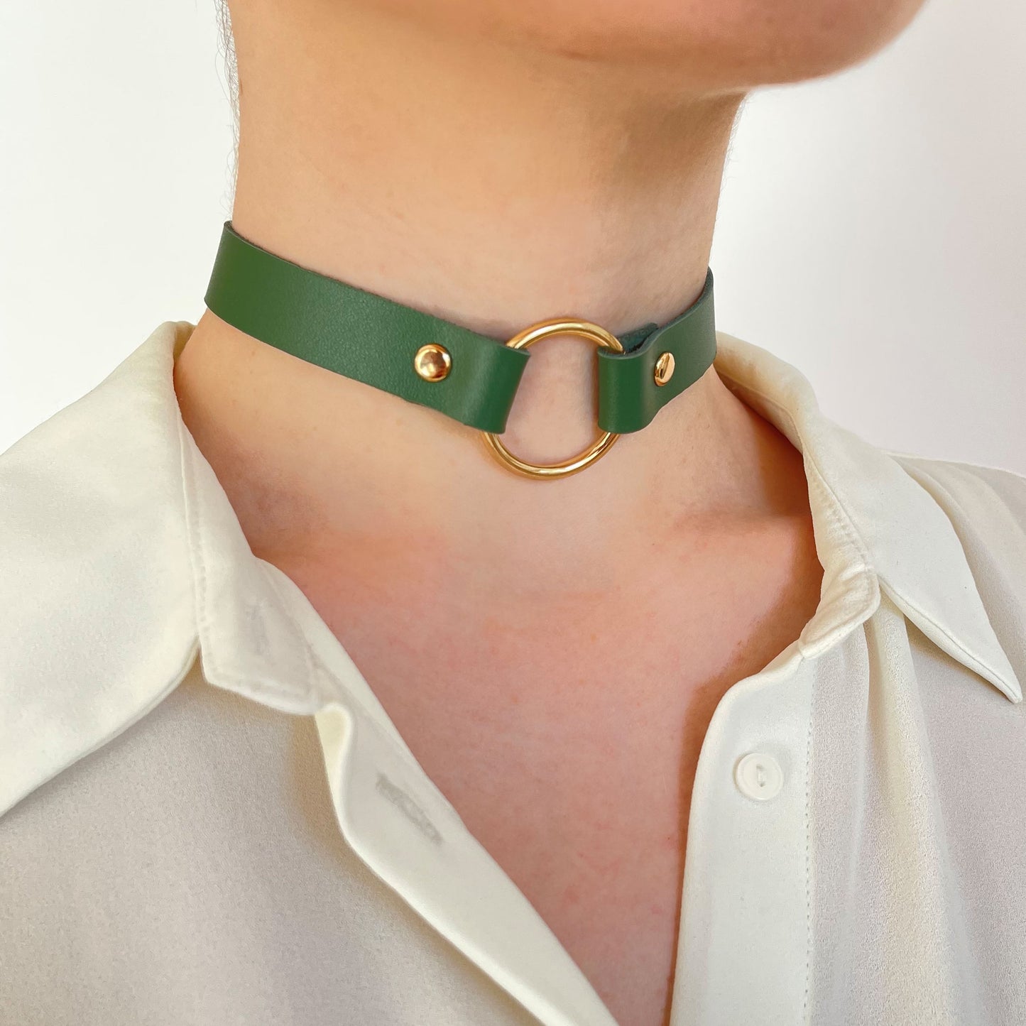 Green leather choker with gold O-ring – angled front view on white blouse