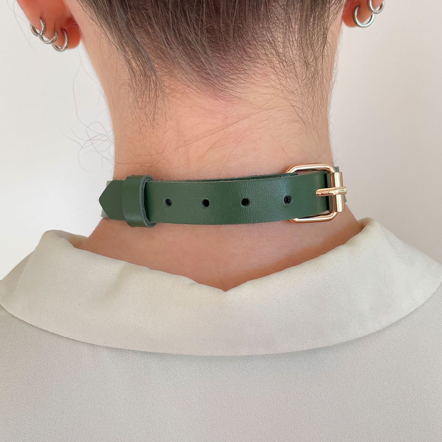 Back view of green leather choker with gold buckle and adjustment holes