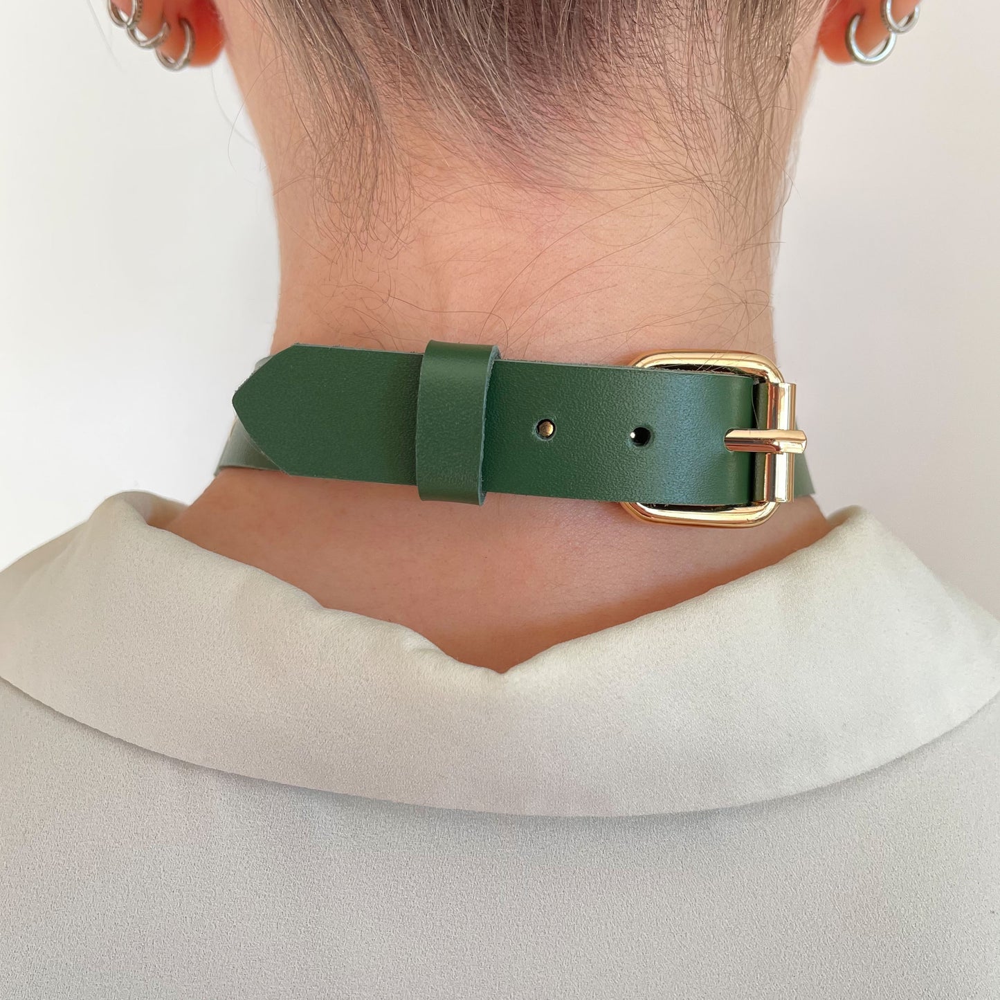 Back view of green leather choker with gold adjustable buckle and clean leather finish.