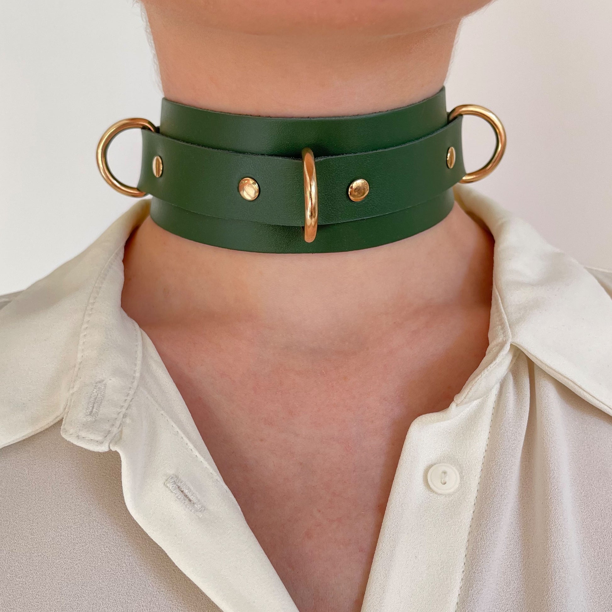 Green leather choker with gold D-rings – front view on neck with white blouse.