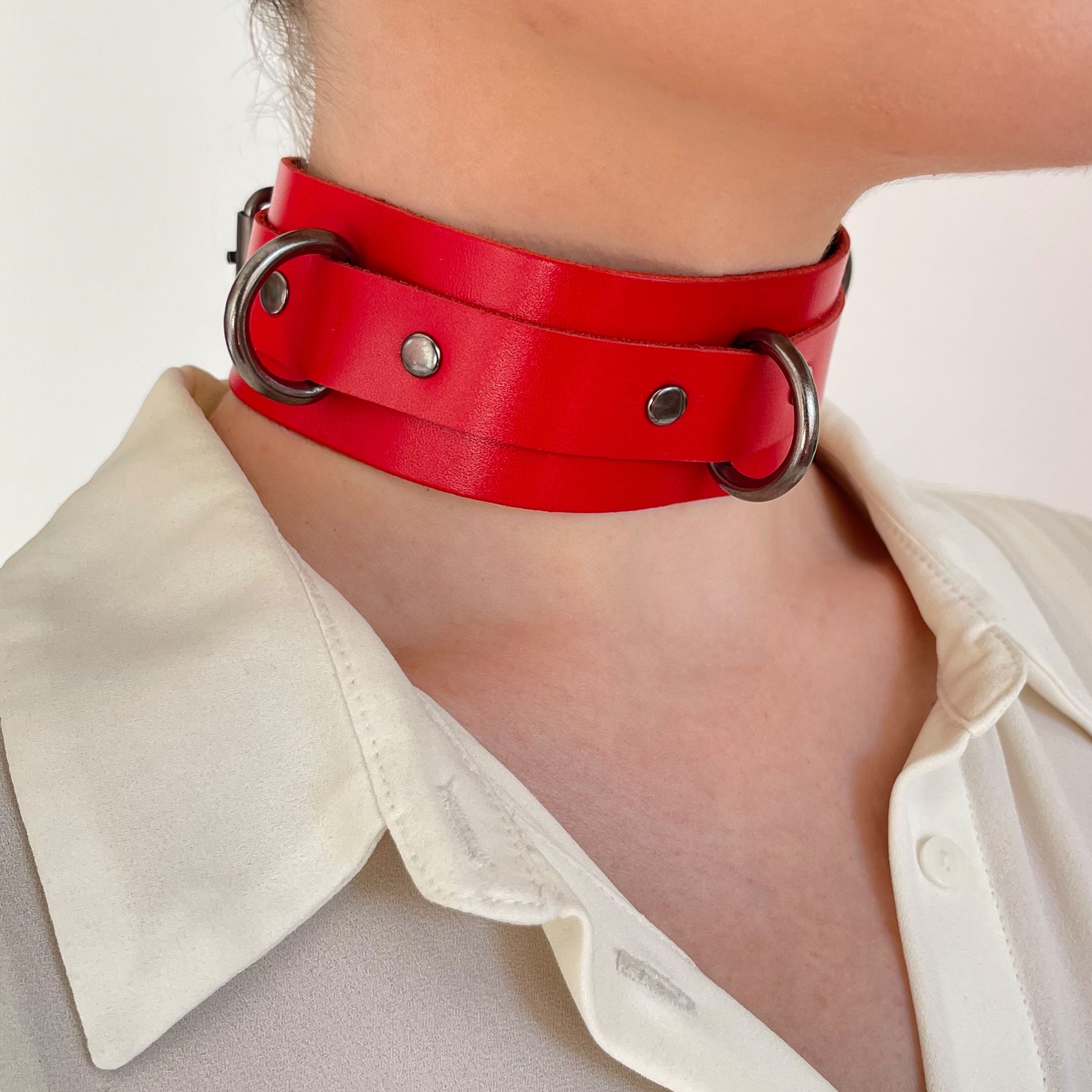 Red leather choker with black D-rings – side view on model wearing ivory blouse.