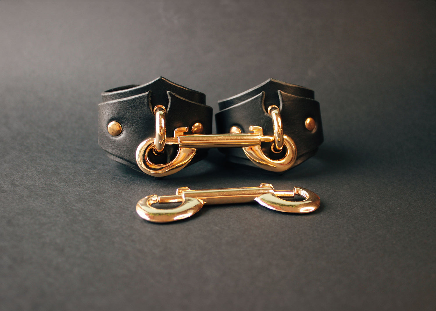 Leather Diamond Handcuffs with gold hardware on a photo.