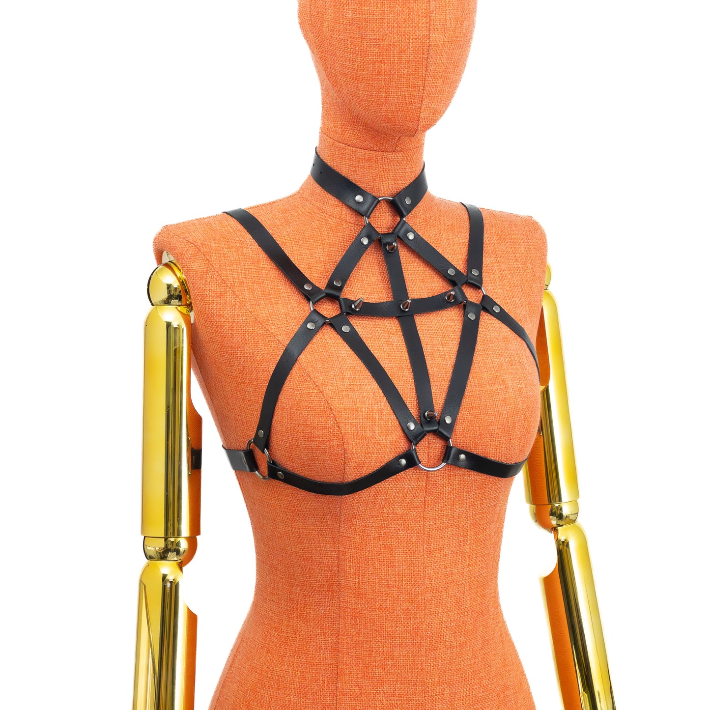 Black genuine leather gothic cross open bust chest harness bra on mannequin, dark nickel hardware, front three-quarter view showing choker connection, cross straps with spikes, lower ring between breasts and horizontal underbust strap shaping bra outline without cups.