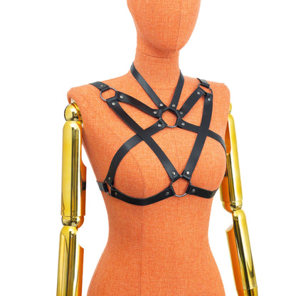 Black leather harness on an orange mannequin with gold arm pieces against a white background