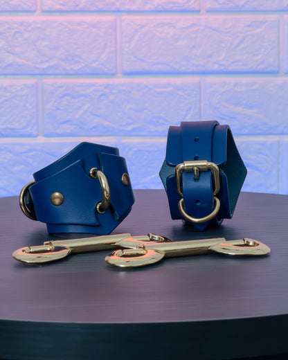 Blue leather handcuffs and leads on a dark surface with a light blue tiled wall background.