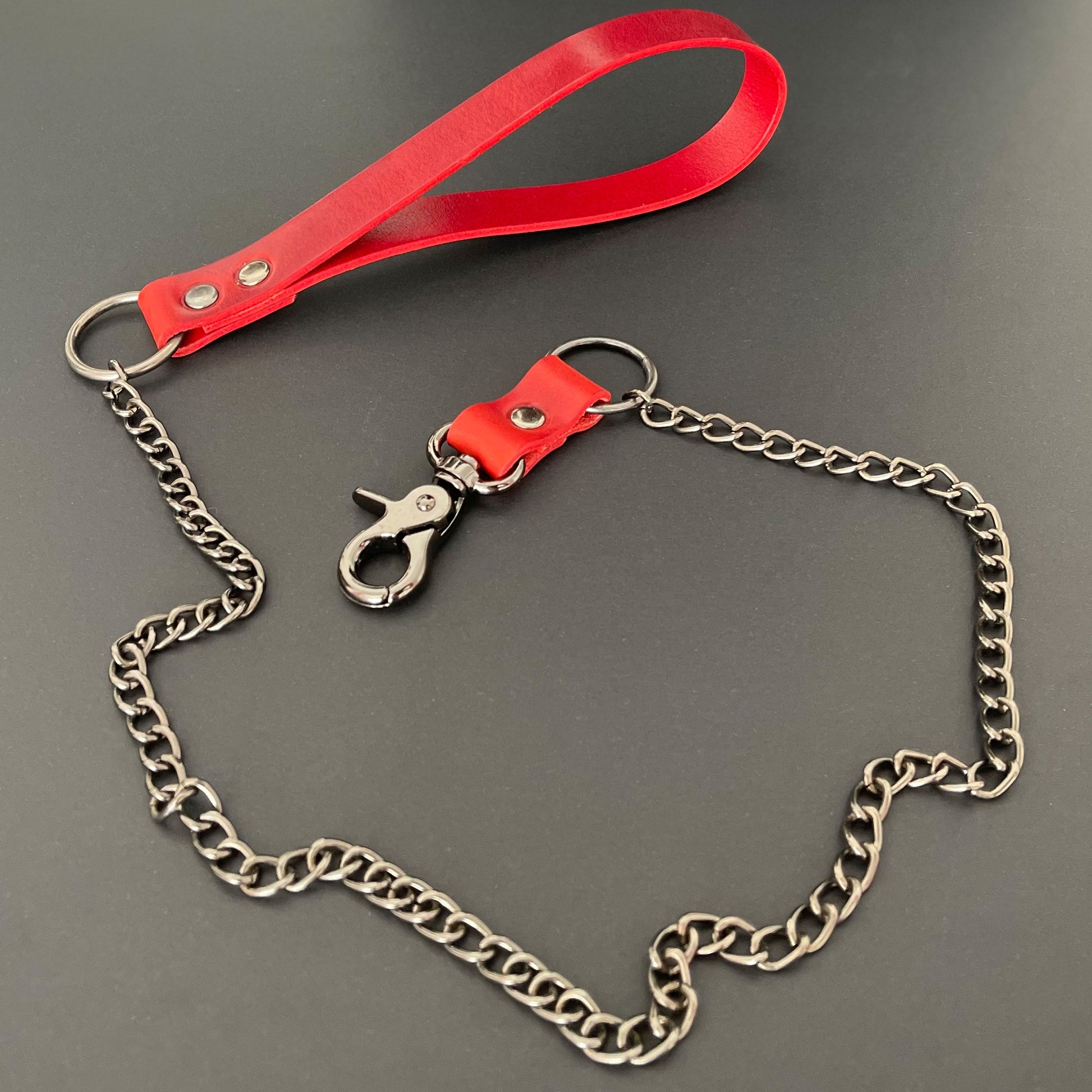 Red leather curb chain leash on a gray background