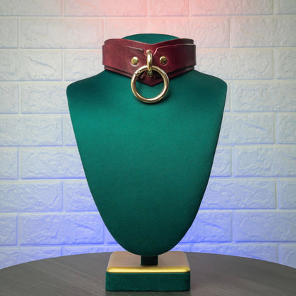 Marsala mannequin head with a brown leather belt and gold ring on a textured white background