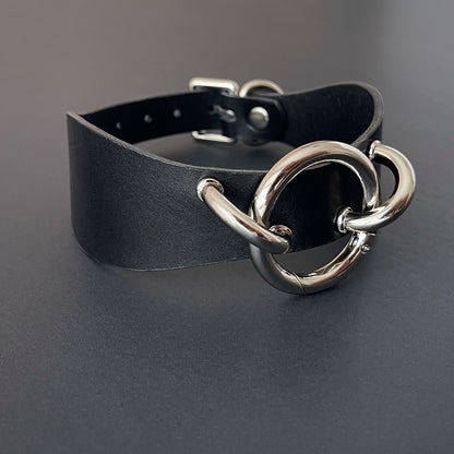Black leather choker with silver metal clasp on a dark background