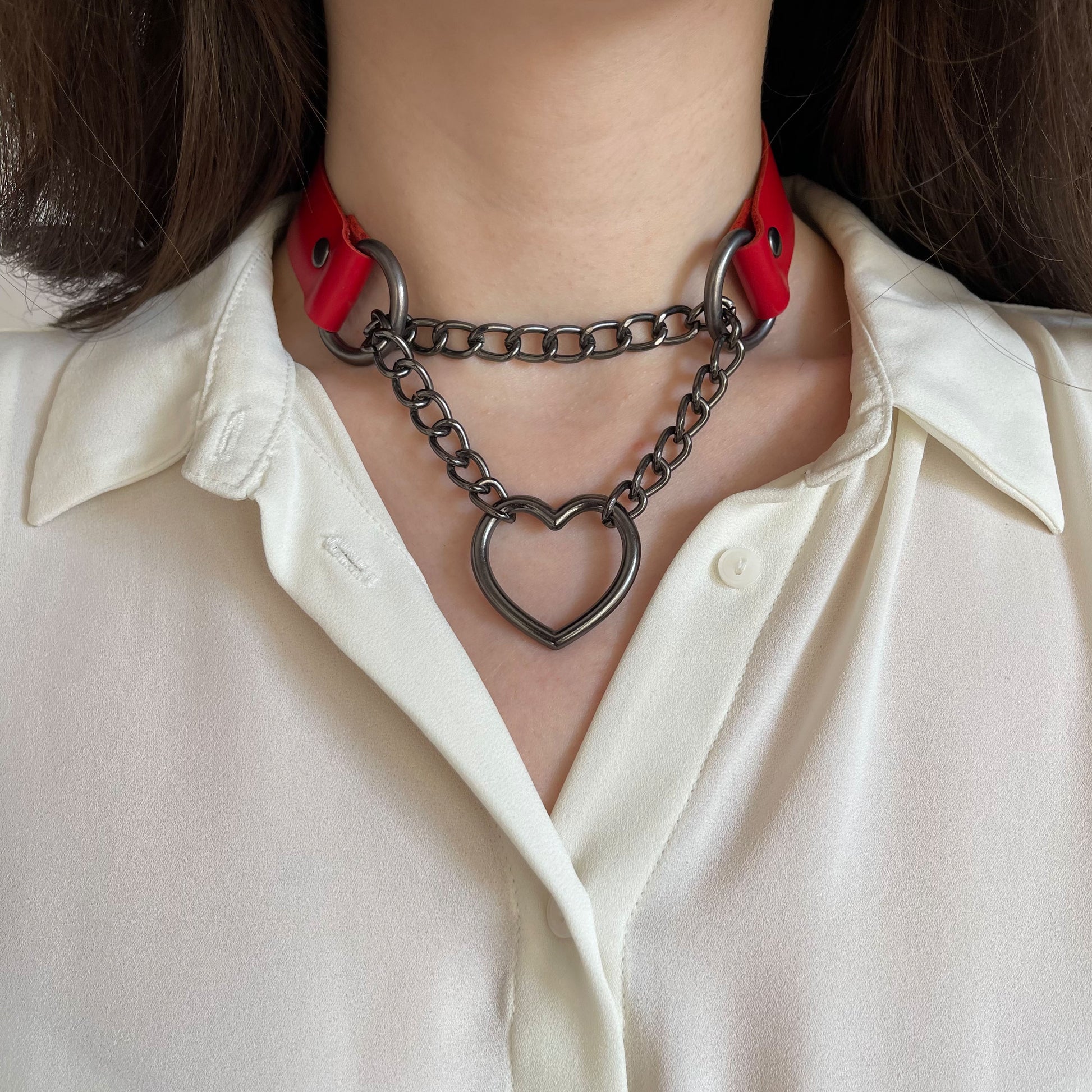 Red genuine leather choker with dark metal chain and heart ring, close-up front view
