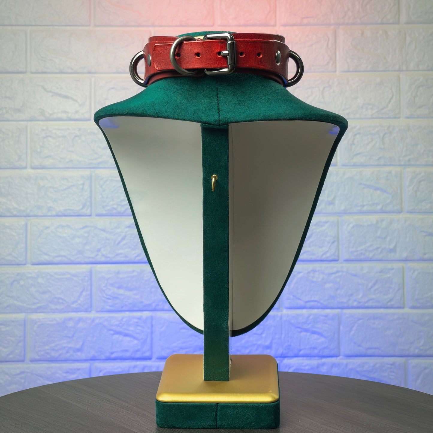 Green lamp with a red collar on a textured white background