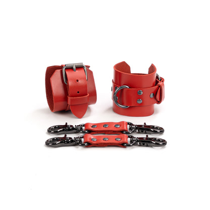 Red leather handcuffs with metal hardware shown on a white background, featuring 6 cm (2.36 in) wide cuffs and 2.5 cm (0.98 in) adjustable straps, with leather connectors and metal carabiners placed in front.