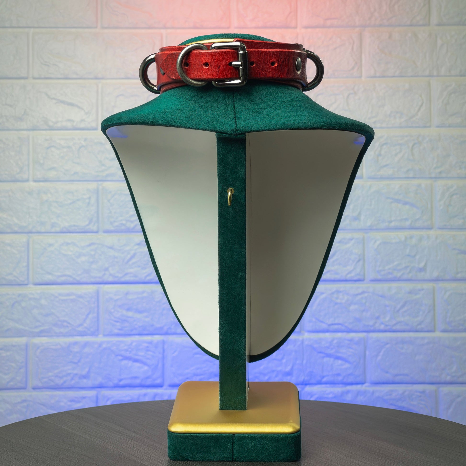 Green lamp with a red collar on a textured white background
