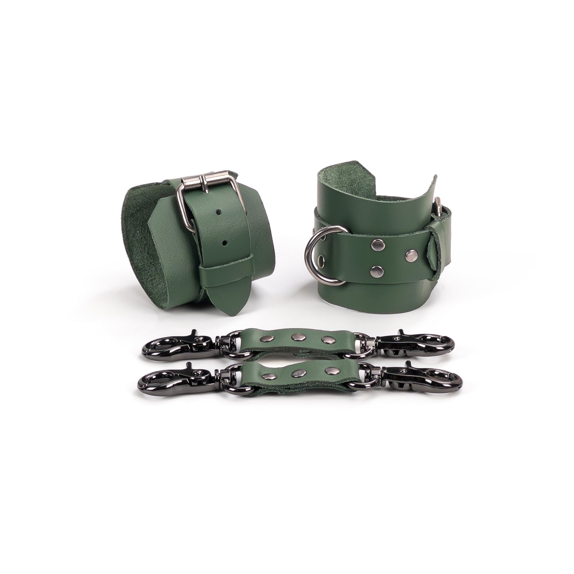 Two green genuine leather ankle cuffs with dark nickel hardware displayed flat, one shown from the buckle fastening side and the other angled to show the metal D-ring. Each cuff has a 6 cm (2.36 in) wide base and a 2.5 cm (0.98 in) strap, with two green leather connectors placed in front.