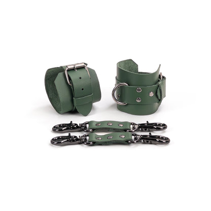 Green leather handcuffs with dark nickel hardware displayed on a white background, made from leather 1.4–1.8 mm (0.055–0.071 in) thick, cuff width 6 cm (2.36 in), strap width 2.5 cm (0.98 in), with leather connectors and carabiners.