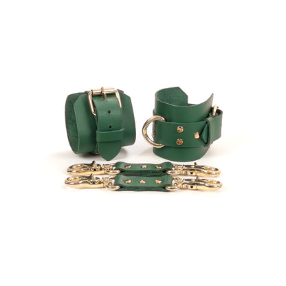 Green leather handcuffs with gold-tone hardware displayed on a white background, made from leather 1.4–1.8 mm (0.055–0.071 in) thick, cuff width 6 cm (2.36 in), strap width 2.5 cm (0.98 in), with leather connectors and carabiners.