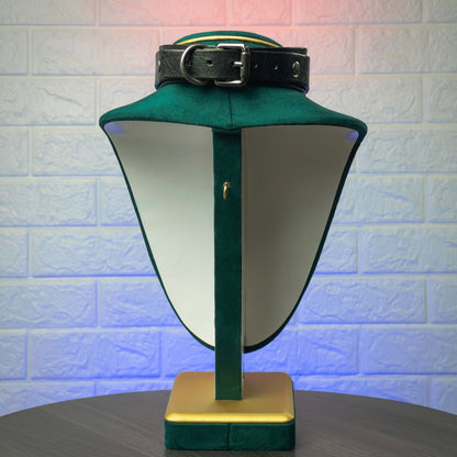 Green visor with a black strap on a stand against a textured white wall.