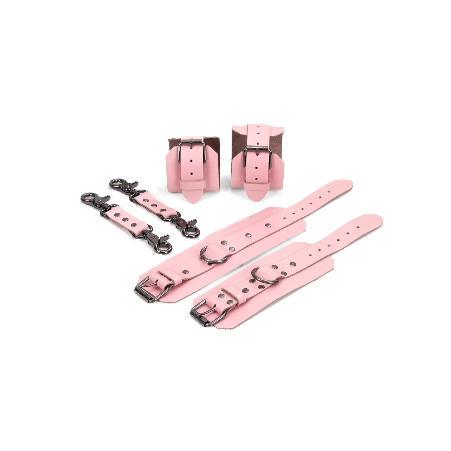 Pink leather BDSM set laid flat: wrist cuffs and ankle cuffs with buckle straps, rivets, adjustment holes, and dark nickel hardware. A 2.5 cm D-ring is visible on each cuff. Two matching leather connectors with dark nickel carabiners on both ends are placed beside the set.