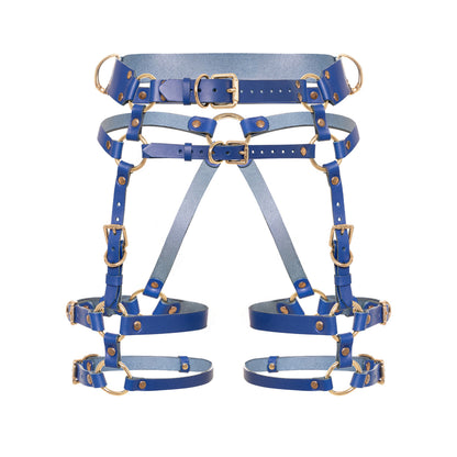 Front view of the Torquea leather butt harness with a wide waist belt, adjustable hip belt, front support straps, double adjustable thigh straps, side D-rings, and gold-tone metal hardware.