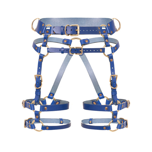 Front view of the Torquea leather butt harness with a wide waist belt, adjustable hip belt, front support straps, double adjustable thigh straps, side D-rings, and gold-tone metal hardware.