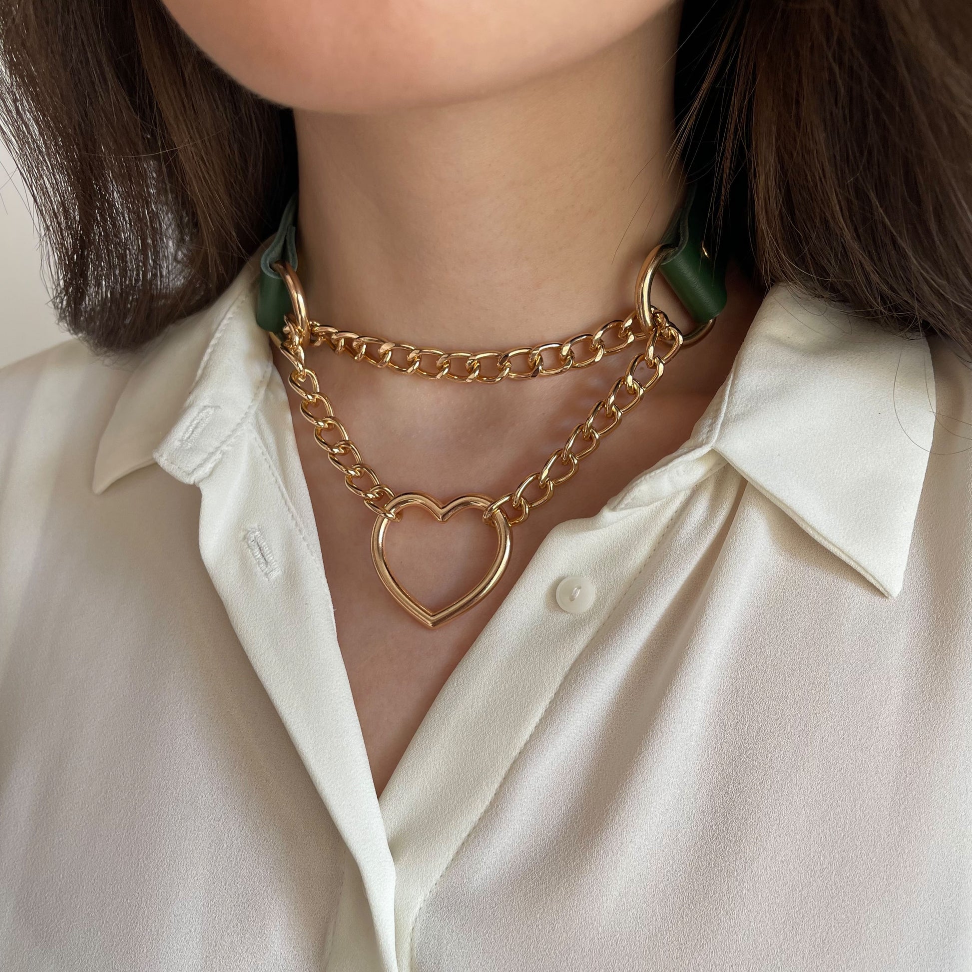 Green leather choker with gold heart-shaped hardware on neck, side angle