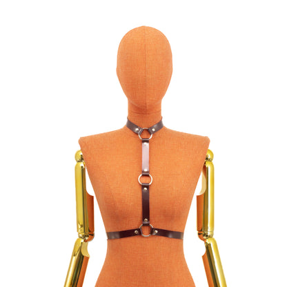 Bondage Harness Choker with Three O-Rings on mannequin reversed orientation, front view, marsala leather and gold metal hardware, central vertical strap positioned between chest with three O-rings and waist straps closing with buckle.