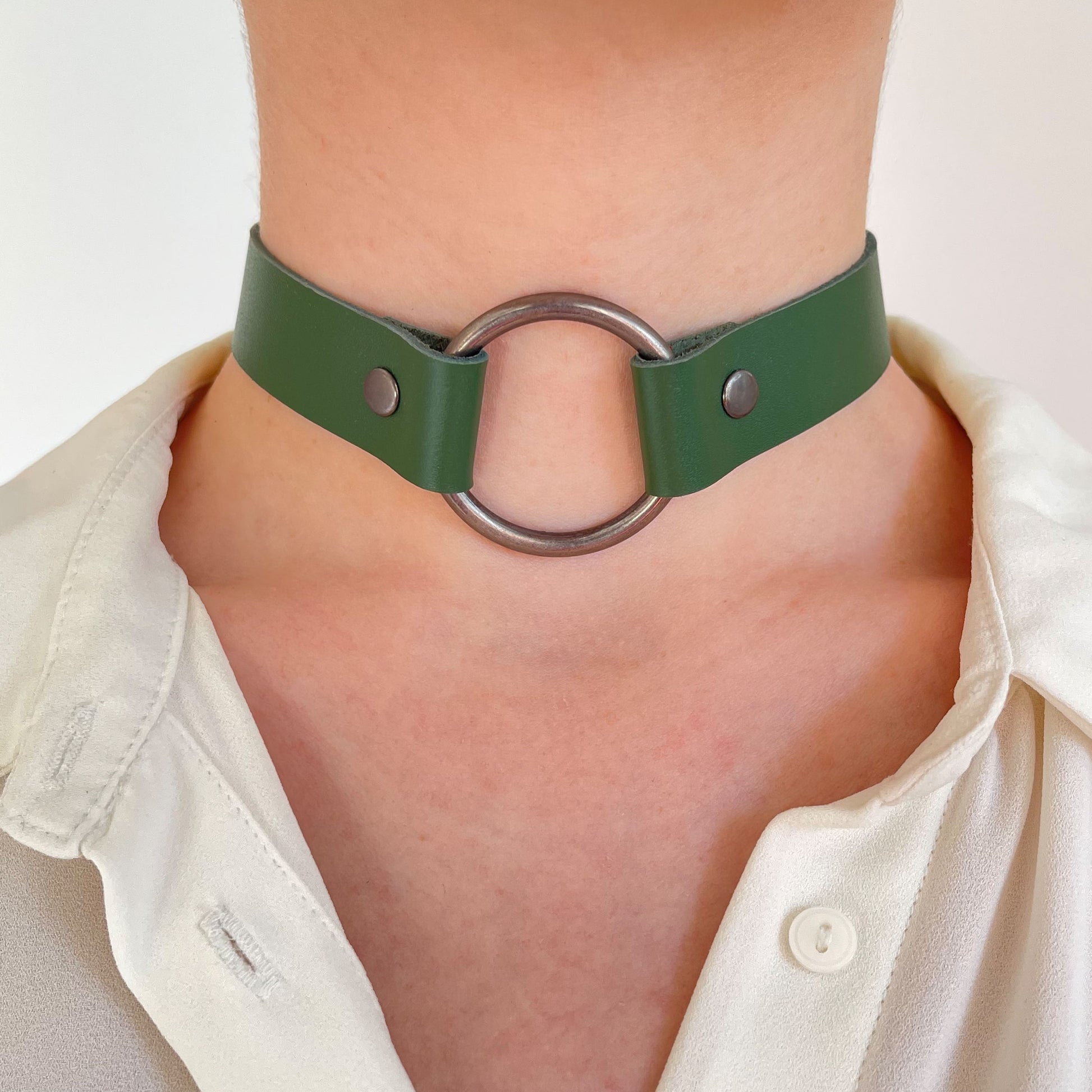 Straight-on view of green choker with large gunmetal O-ring and hardware, worn on neck