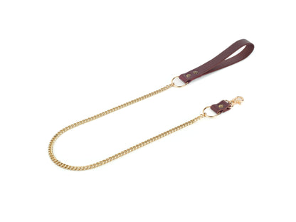 Gold chain strap with leather handle on a white background