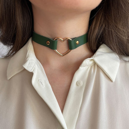 Green leather choker with gold heart-shaped ring – centered front view on model with cream shirt