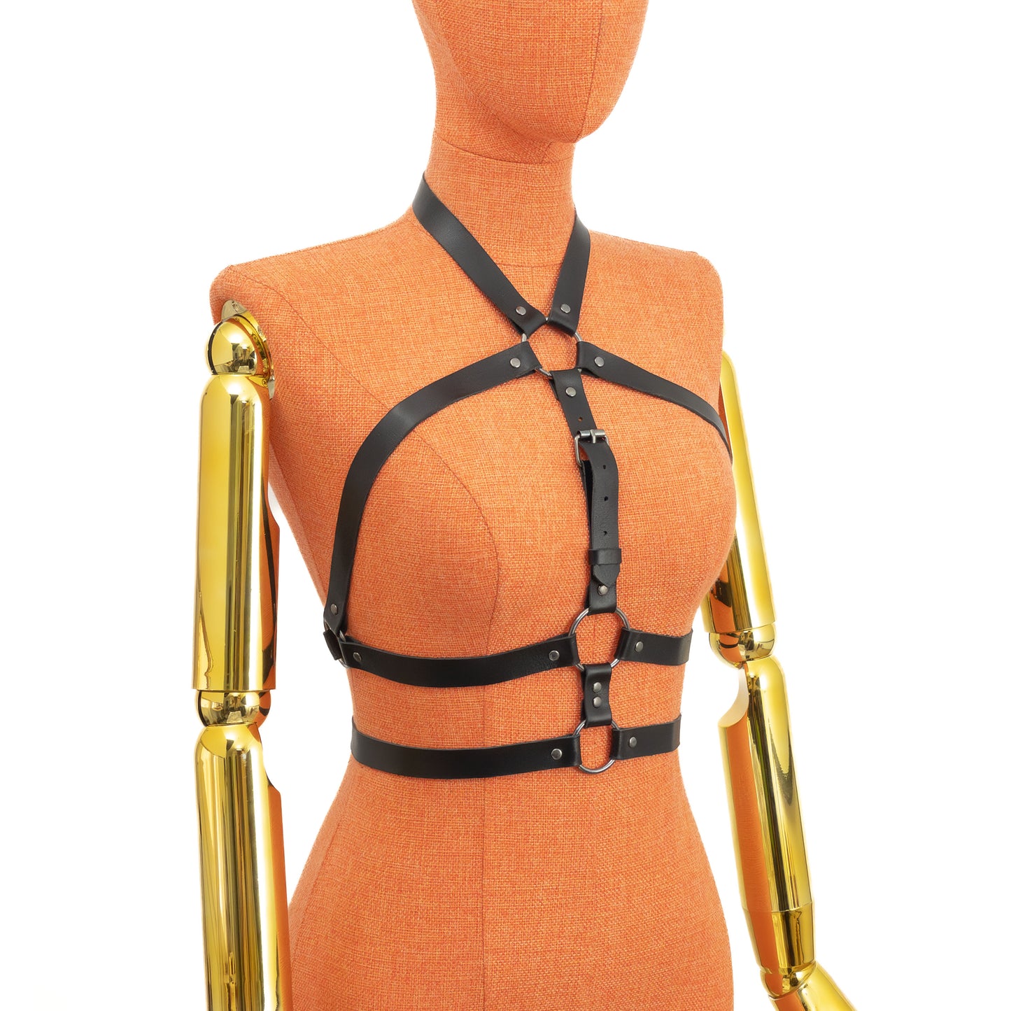 Three-quarter side view of a black leather open chest harness on a mannequin, showing how straps wrap from the neck ring toward the underbust ring and continue around the torso, forming a double underbust line; dark nickel buckles and rings visible; leather thickness 1.4–1.8 mm.