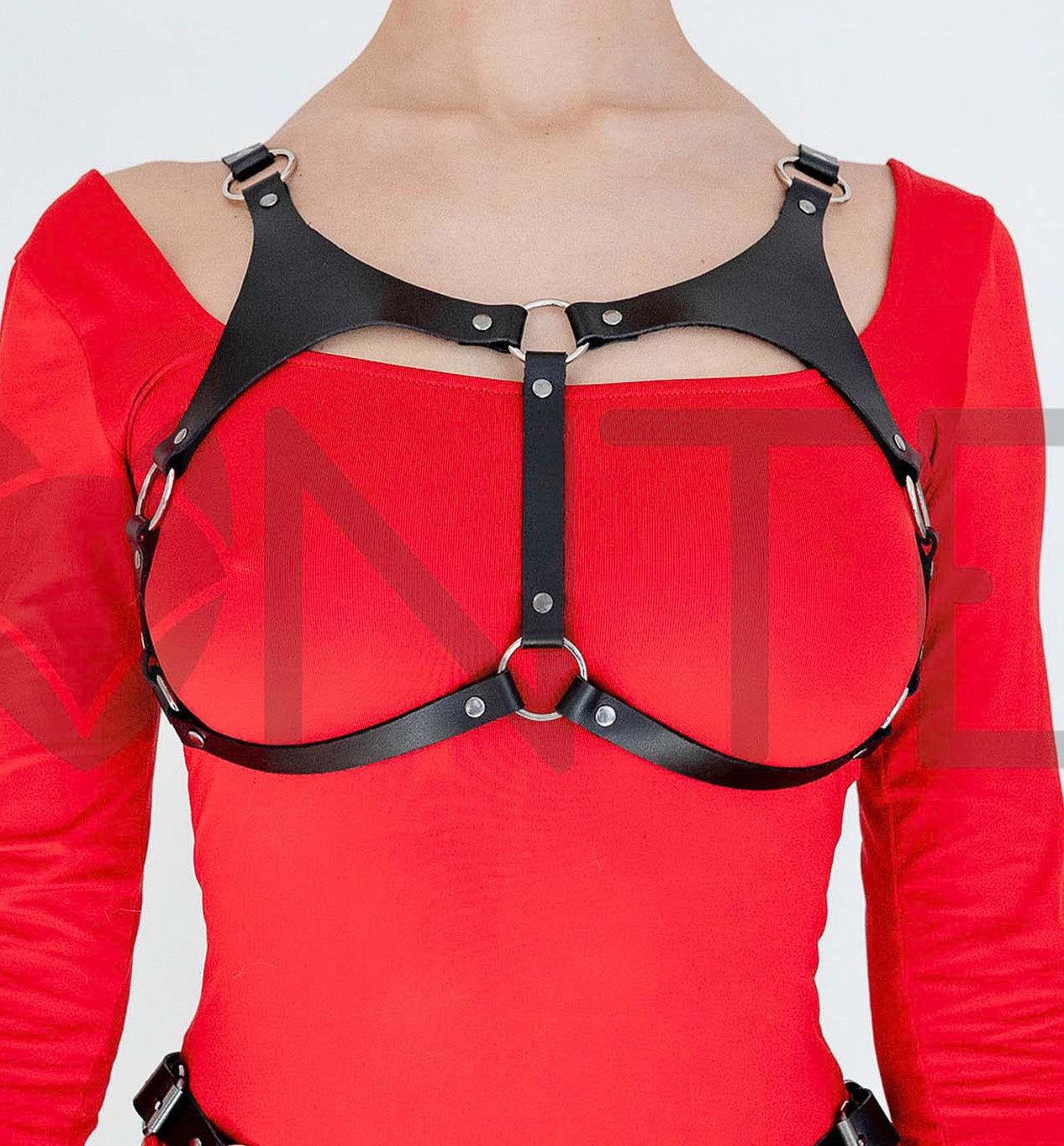 Open Cup Leather Bra worn on model, front view, black leather open bust structure with triangular upper panels, central O-ring connection and lower O-ring under bust, underbust straps curving outward to side rings, silver-tone metal details; strap width 5/8 inch (15 mm), leather thickness 3–4 oz (1.4–1.8 mm).