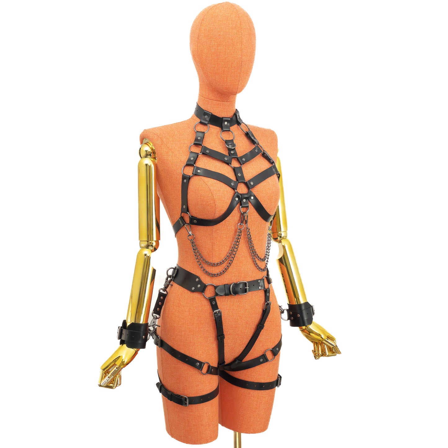 Side angled view of a full leather bondage set with a neck-attached chest harness that wraps under the bust and fastens on the back, leaving the breasts open, and a waist garter harness with straps passing over the hips and through the crotch while keeping the crotch open. Wrist cuffs are worn on the arms and attached with leather connectors and carabiners to D-rings on the garter belt.