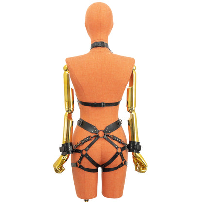 Back view of the set showing the back closure of the chest harness, the waist belt, and the garter straps wrapping around the hips, with the wrist cuffs attached to the central O-ring at the back of the waist.