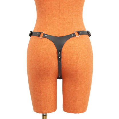 Rear view of black leather thong on orange mannequin. A small triangular back panel connects to side straps through rings, and the center strap runs between the legs with screw-based length adjustment.
