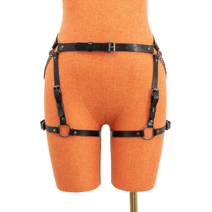 Front view of the black genuine leather butt garter displayed on an orange mannequin. A narrow waist strap with a center front buckle connects to vertical adjustable straps and horizontal thigh straps positioned evenly around both legs.