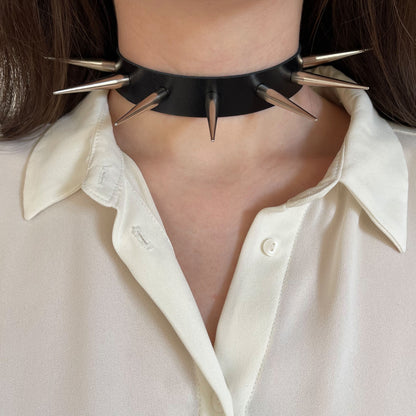Leather spiked collar worn on the neck, front view, with long silver-colored cone spikes