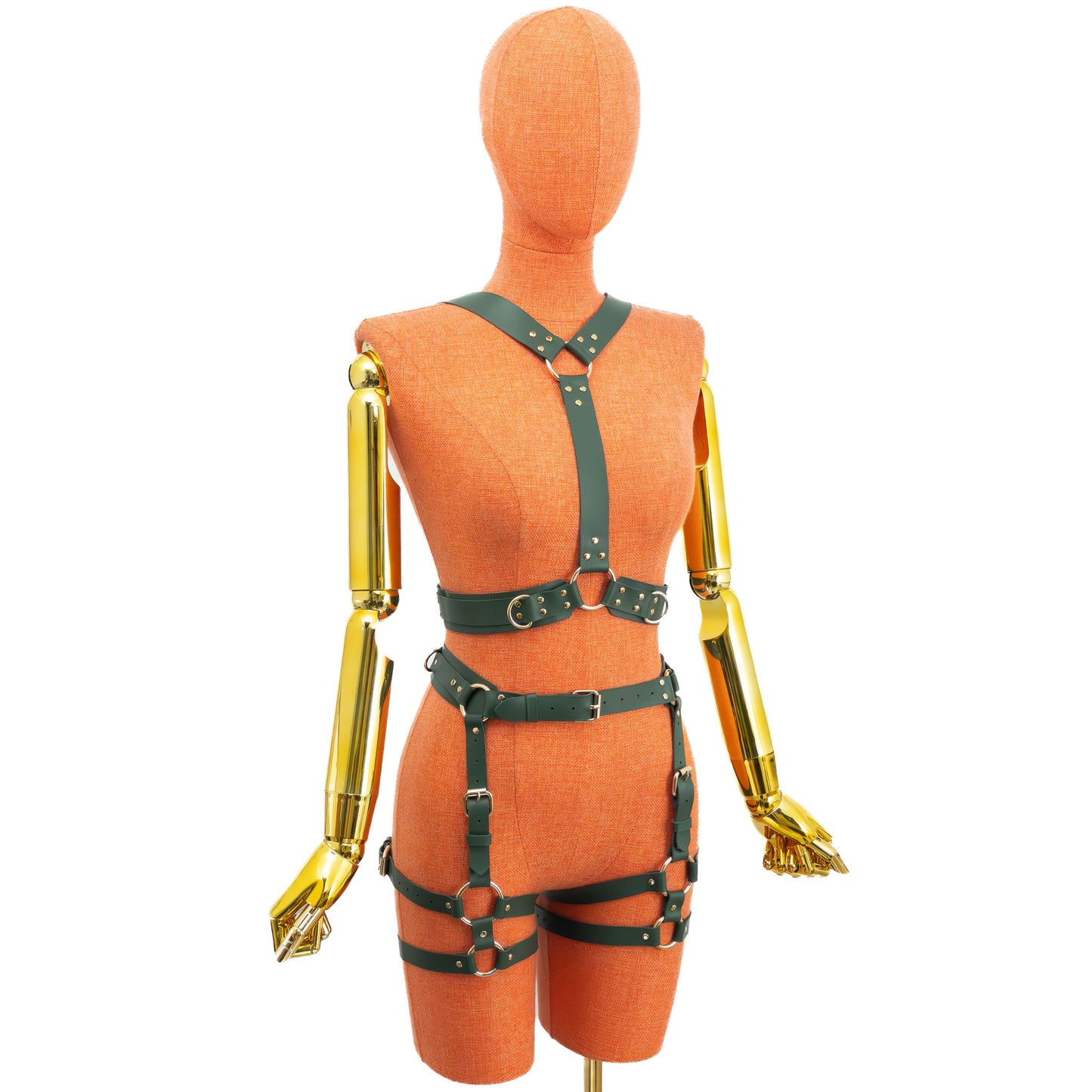 Front view of a green leather wide reversible body harness set on a mannequin, showing the reverse side with one central vertical front strap, a top round ring at the upper chest, wide shoulder straps meeting near the neckline, a waist belt, garter straps, and gold hardware.