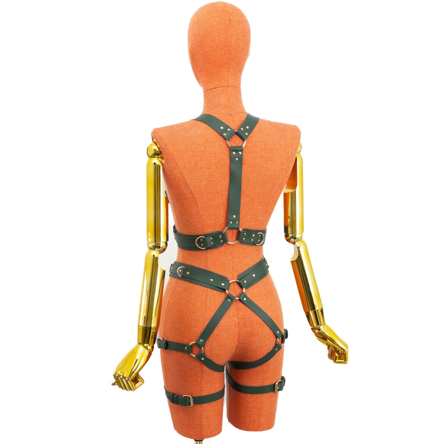 Back view of a green leather wide reversible body harness set on a mannequin, showing the reverse side with one central vertical back strap running from the upper ring to the back waist section, an underbust belt, a waist belt, garter straps, and gold hardware.