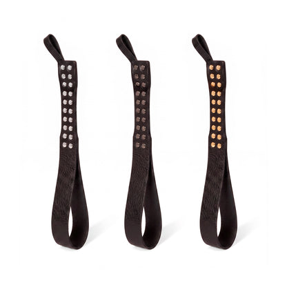 Three leather Loop Core BDSM paddle   black coloring and silver, gold and dark nickel hardware.