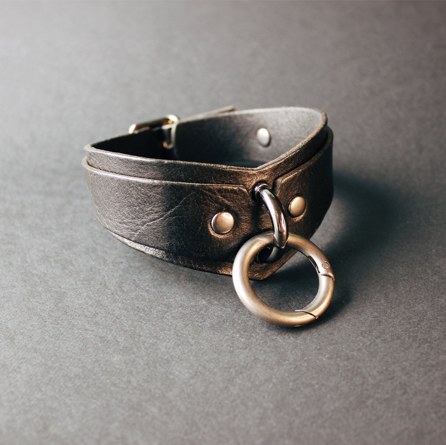 Leather choker with metal ring on a gray background