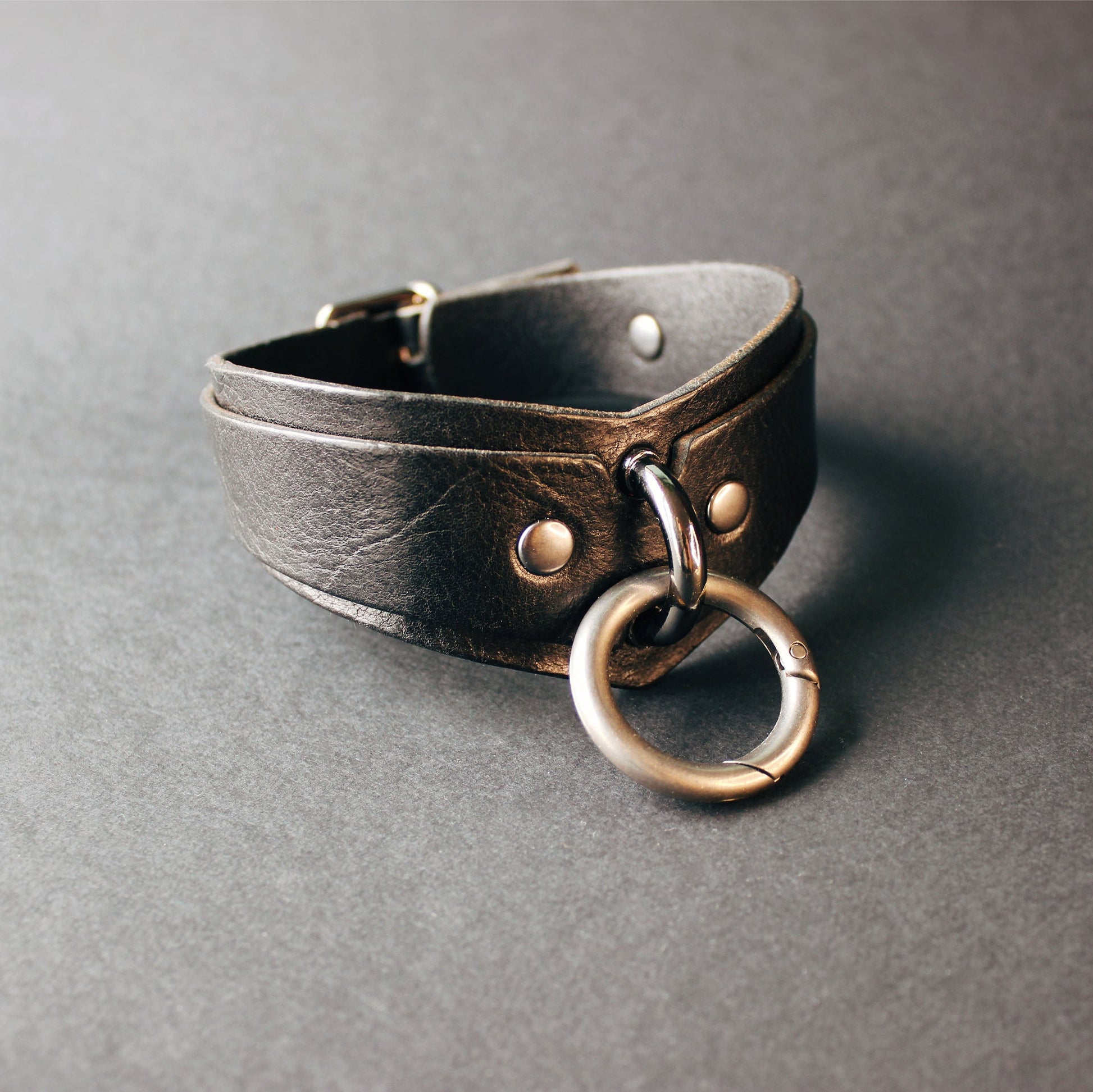 Leather choker with metal ring on a gray background