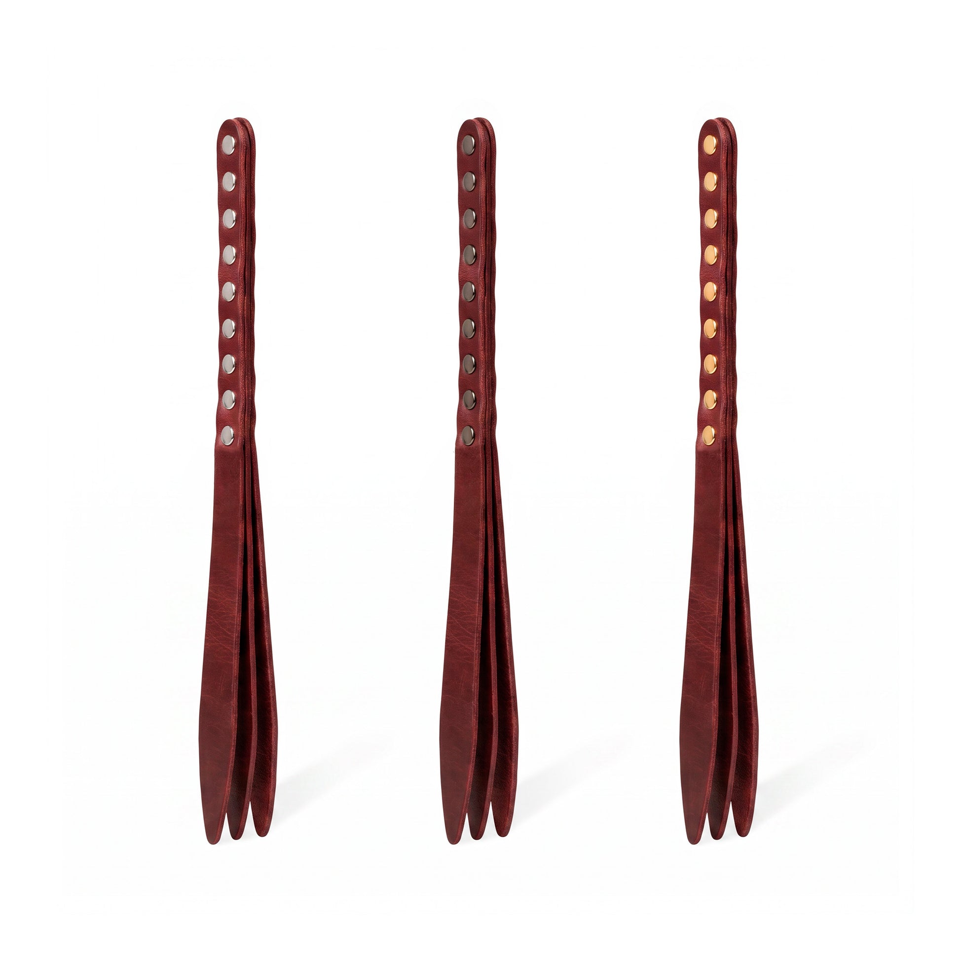 Three marsala leather bdsm paddles with hardware in silver, gold and dark nickel colors.