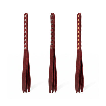 Three marsala leather bdsm paddles with hardware in silver, gold and dark nickel colors.