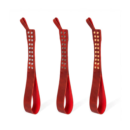 Three leather Loop Core BDSM paddle red coloring and silver, gold and dark nickel hardware.